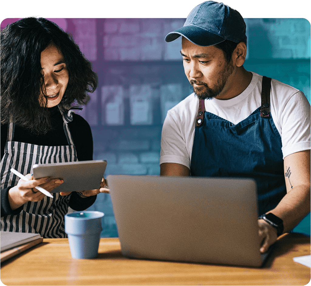 Two shop owners at a laptop